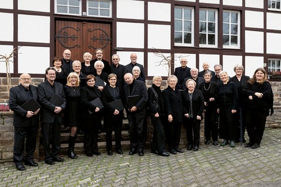 Das Foto zeigt die Sängerinnen und Sänger der Kantorei Rosbach vor dem Fachwerk-Gemeindehaus