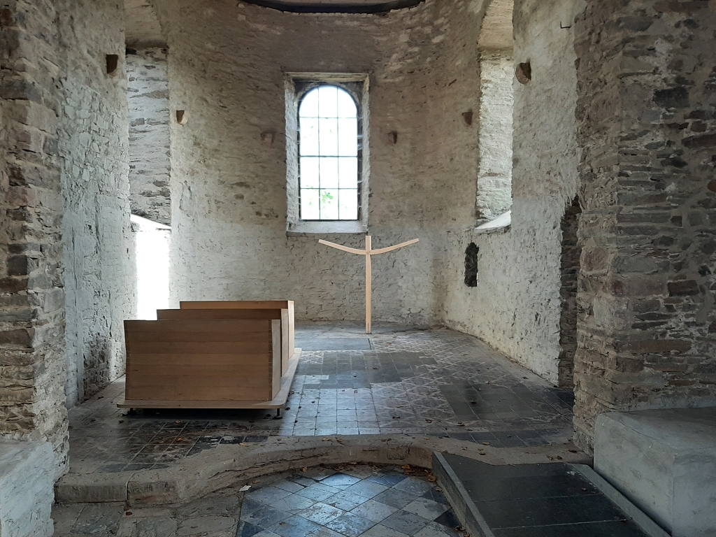 Kapelle mit vier Holzbänken und einem Kreuz 
