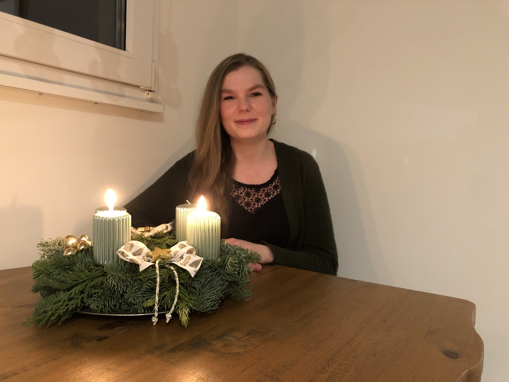 Marissa Ebener mit Adventskranz. Zwei Kerzen leuchten