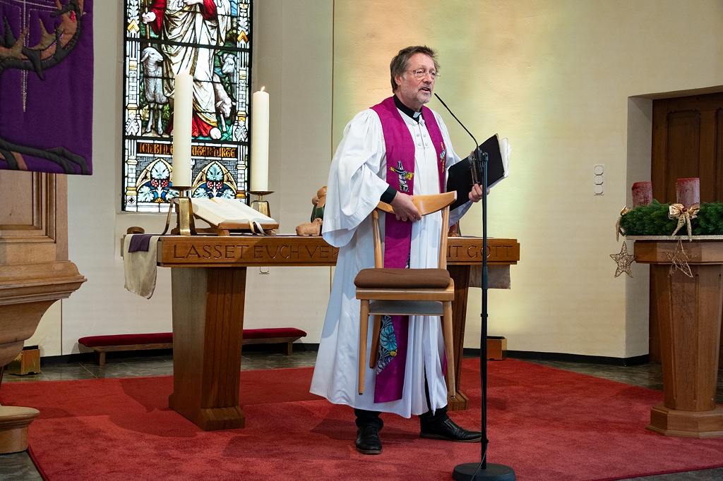 Pfarrer Daniel Boltner trägt einen Stuhl